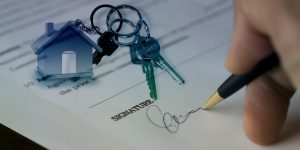 "Mano sosteniendo las llaves de una casa nueva, símbolo de compra de vivienda con respaldo legal."