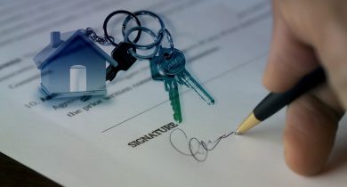 "Mano sosteniendo las llaves de una casa nueva, símbolo de compra de vivienda con respaldo legal."